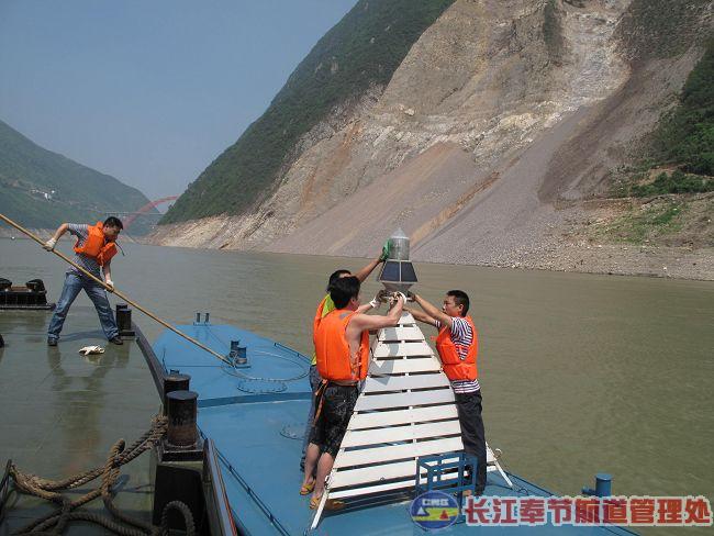Workers from the Chongqing Waterway Bureau install a buoy near the site of the landslide across from Gongjiafang Village  in Wu Gorge. (Photo from the Internet).