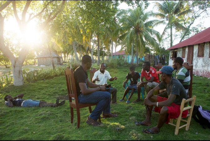 Members of KOPI, a grassroots organization made up of four local groups to press the Haitian government for transparency and community participation in its development plans for the island of Ile-a-Vache, Haiti, meet together on the island. Allison Shelley/The GroundTruth Project