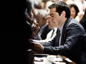 Alexis Tsipras, Greece's prime minister, reads documents after arriving at the Greek parliament to address lawmakers in Athens, Greece, on Friday, July 10, 2015. In an 11th-hour bid to stay in the euro, the government of Tsipras offered to meet most of the demands made by creditors in exchange for a bailout of 53.5 billion euros (US$59.4 billion). Kostas Tsironis/Bloomberg.