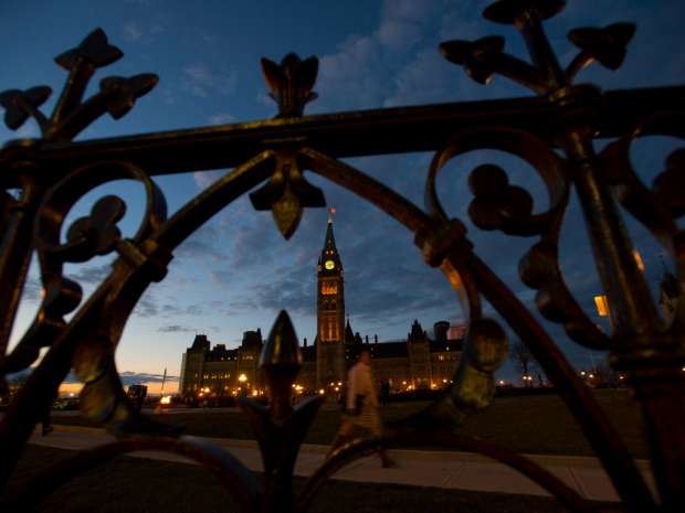 The sun sets behind Parliament Hill in Ottawa. The Canadian Press/Sean Kilpatrick.